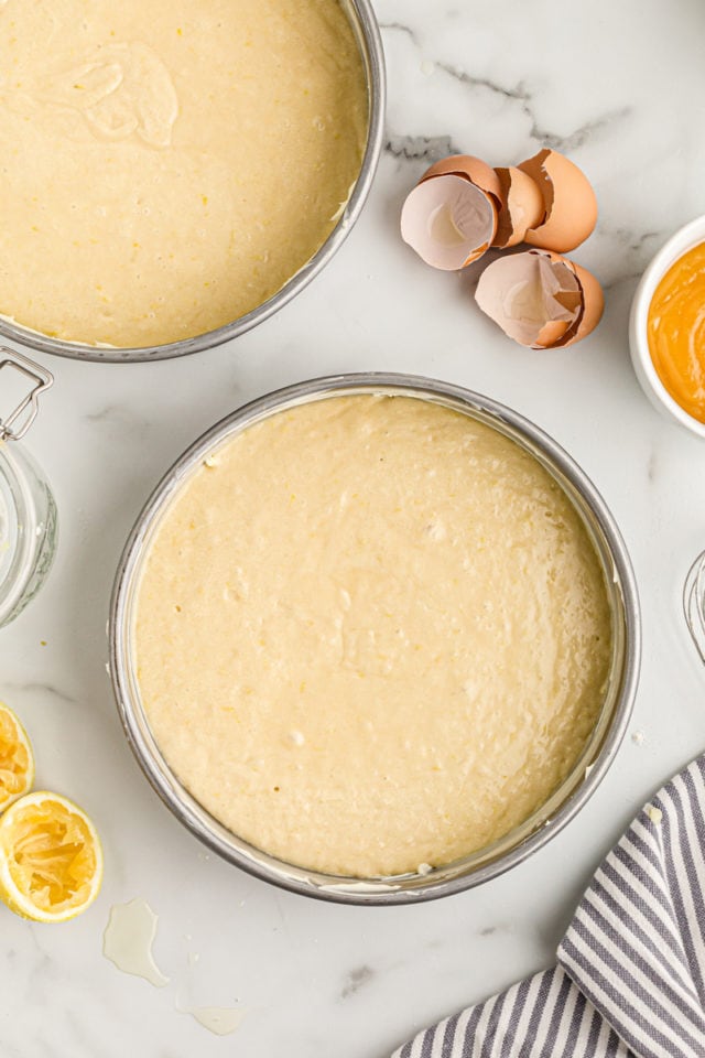 Overhead view of lemon cake batter in two round pans