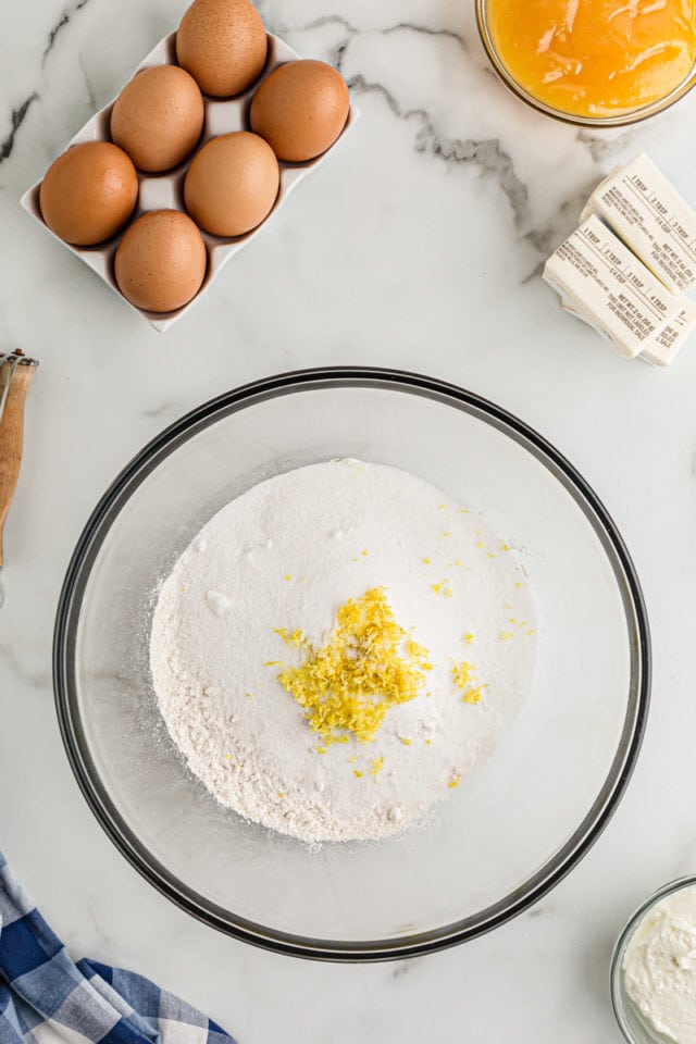 Overhead view of flour, sugar, and lemon zest in bowl