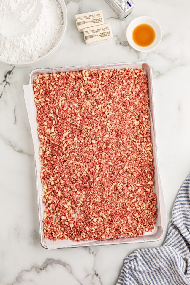 Overhead view of strawberry crunch bits on sheet pan