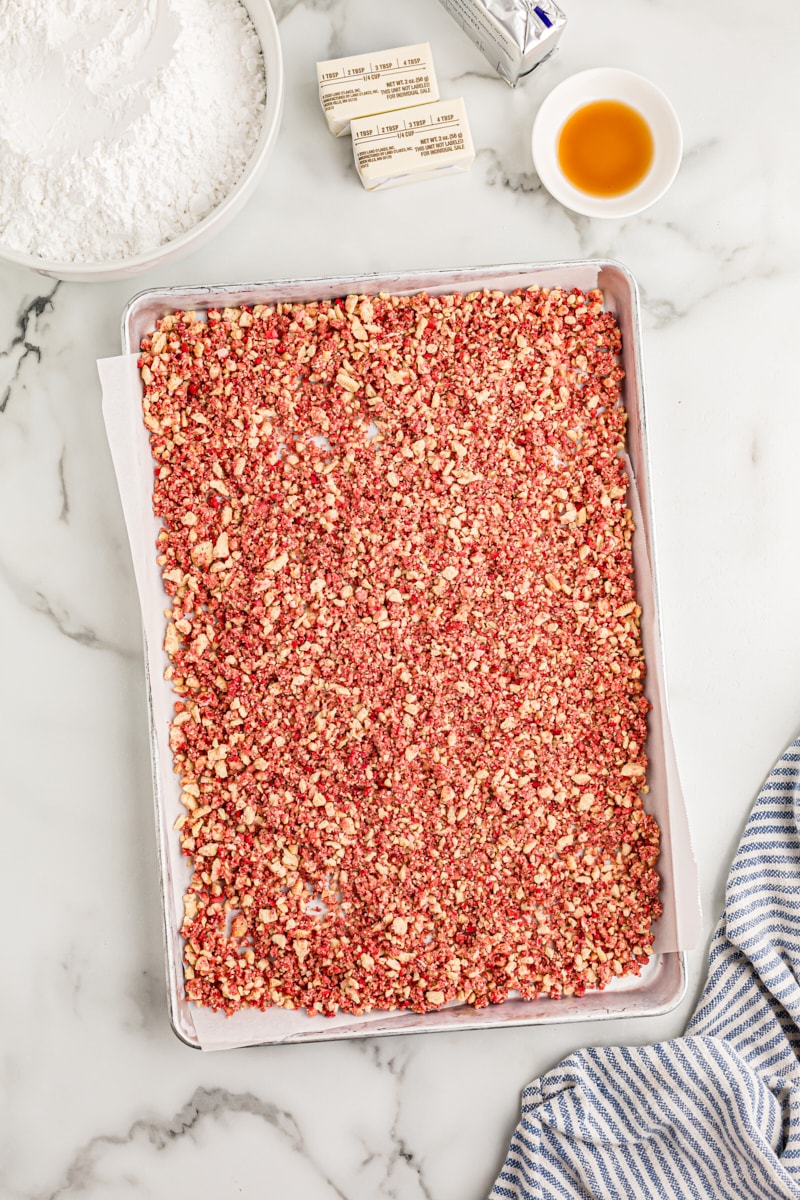 Overhead view of strawberry crunch bits on sheet pan