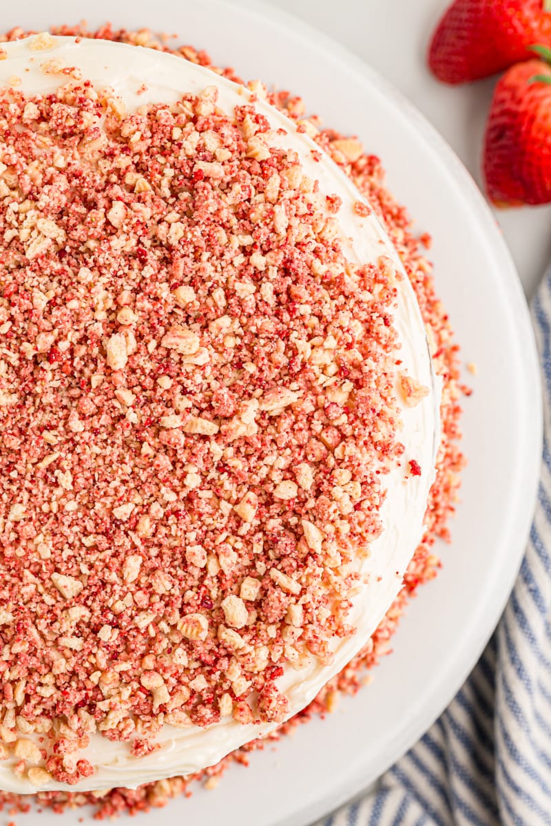 Overhead view of whole strawberry crunch cake on cake pedestal