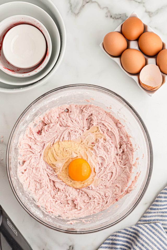 Overhead view of egg cracked into bowl of egg batter