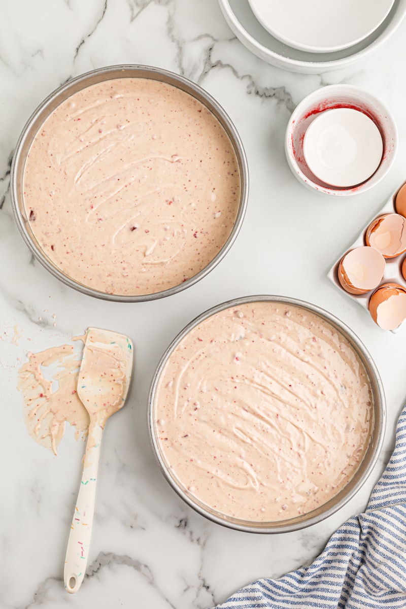 Overhead view of cake batter in two round cake pans