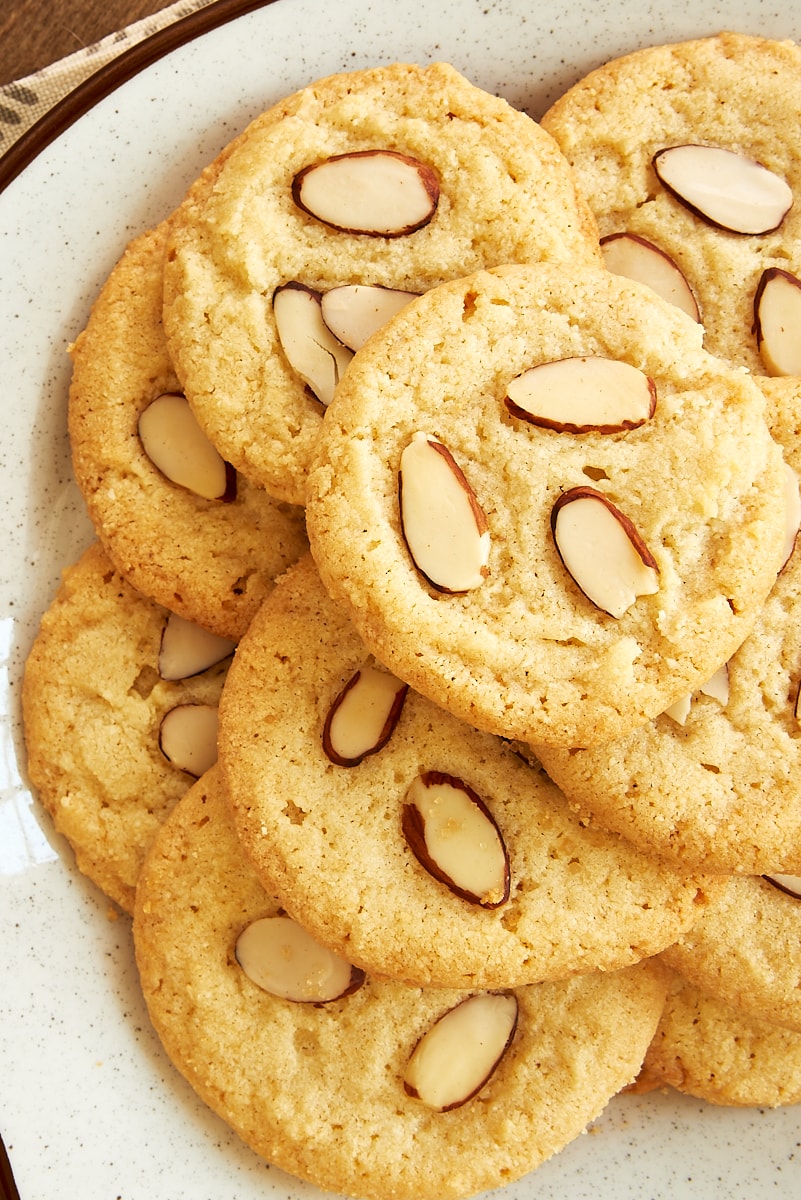 overhead view of almond cookies on a brown speckled white plate