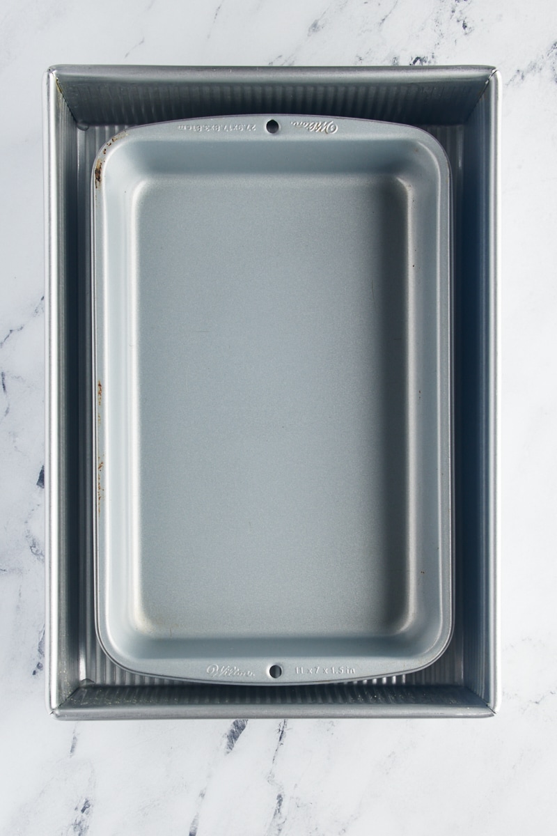 overhead view of an 11" x 7" baking pan nested inside a 9" x 13" baking pan