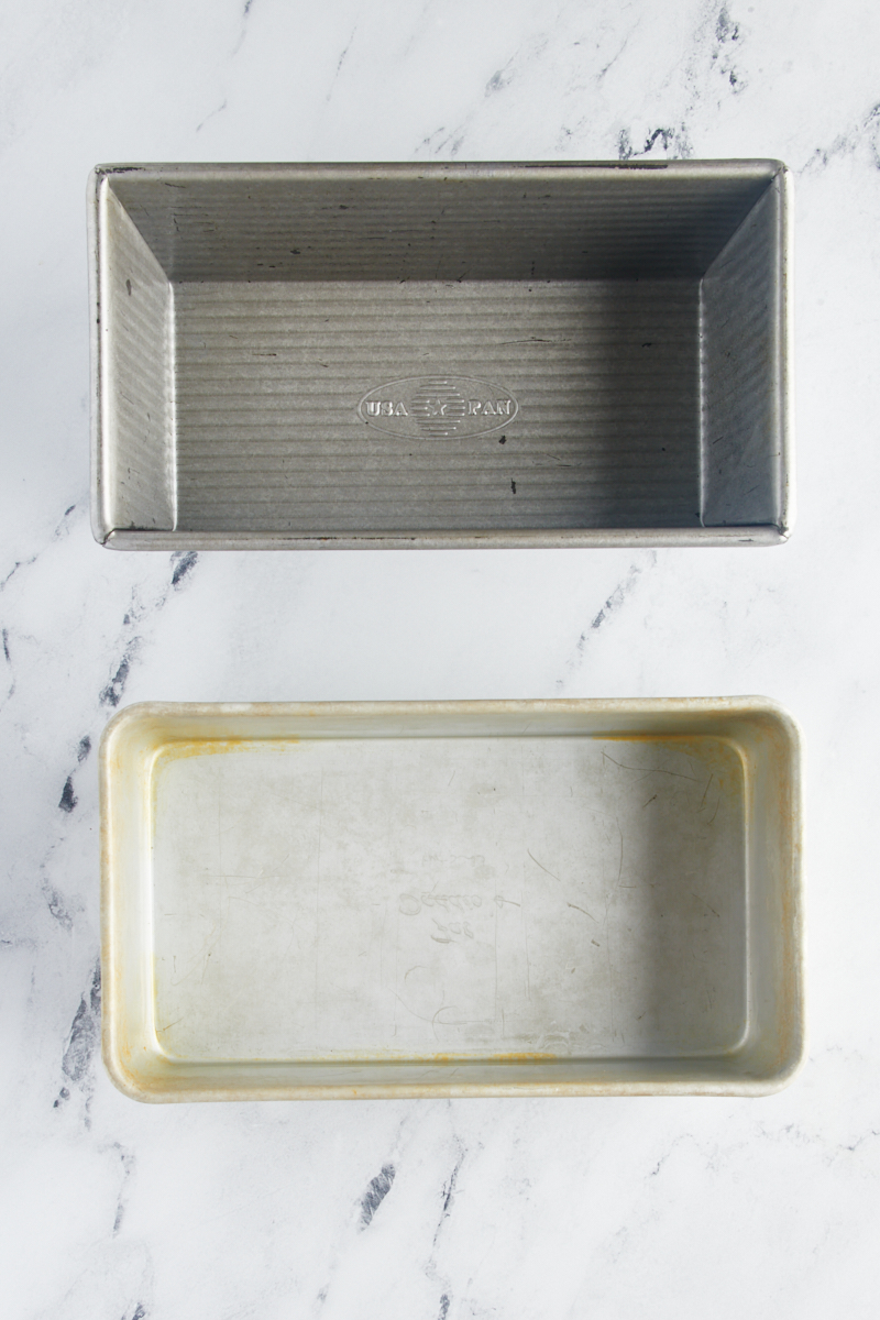 overhead view of two loaf pans on a marble surface