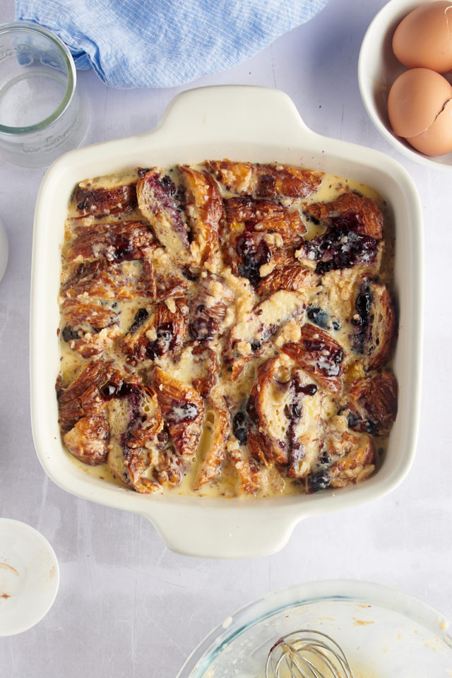 Overhead view of unbaked blueberry croissant bread pudding in baking dish