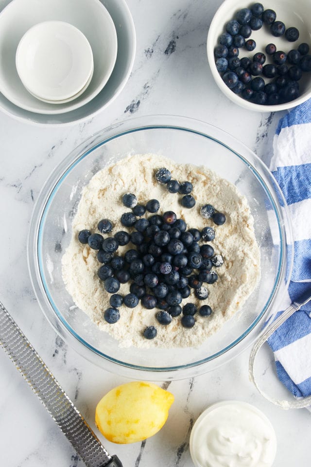 overhead view of blueberries added to dry ingredients for blueberry scones