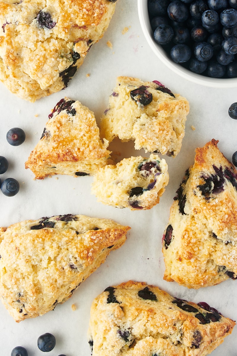 overhead view of three pieces of a blueberry scone surrounded by more scones