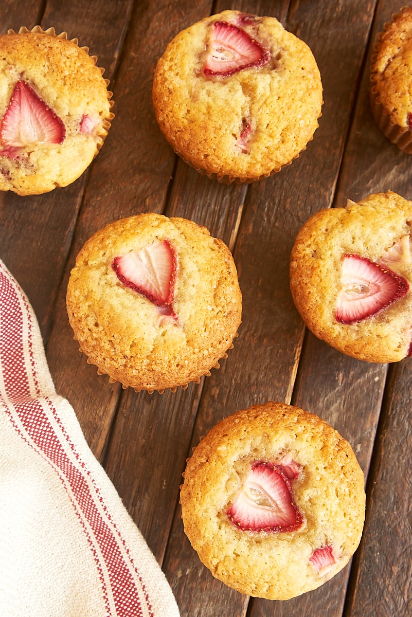 strawberry muffins lined up on a wooden surface