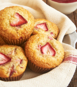 strawberry muffins in a towel-lined shallow bowl