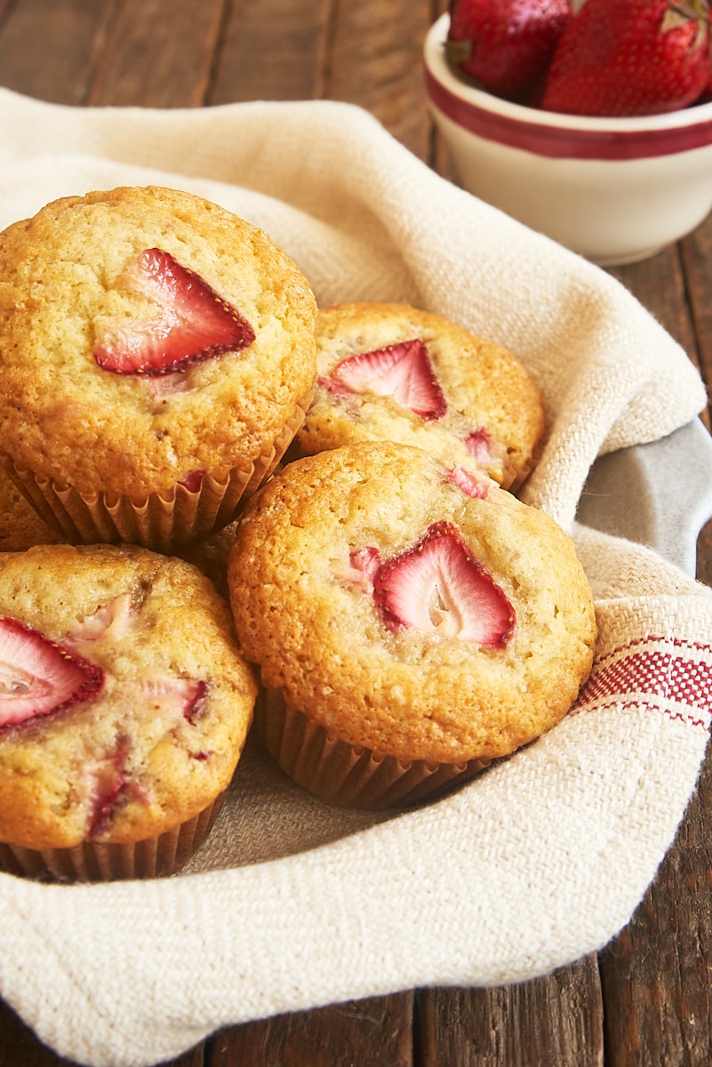 strawberry muffins in a towel-lined shallow bowl