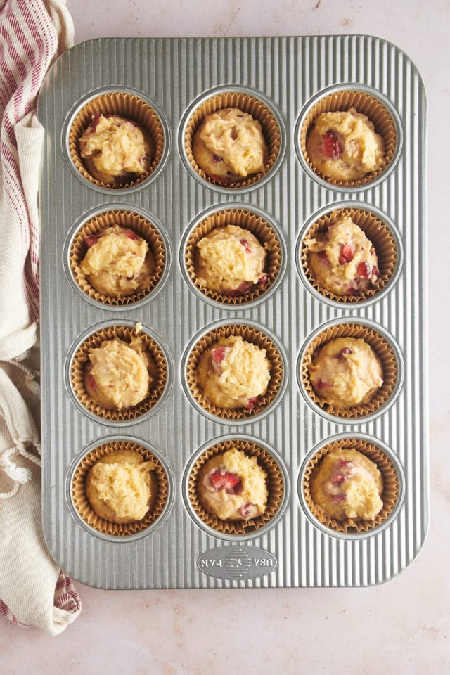 overhead view of portioned strawberry muffin batter in a muffin pan