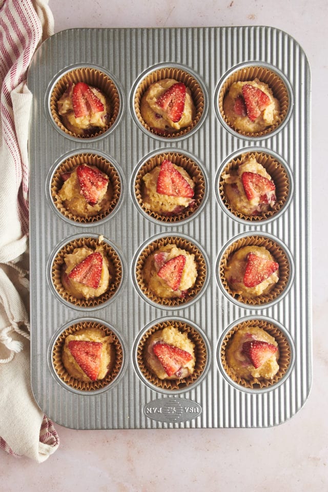 overhead view of strawberry muffins in a muffin pan ready to go into the oven