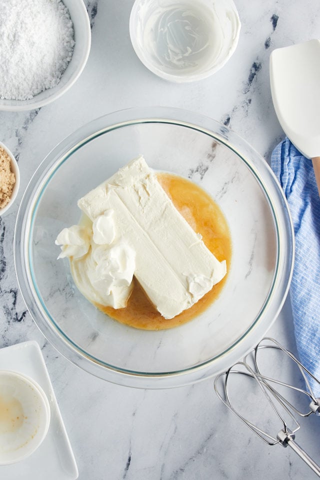 Overhead view of sour cream, vanilla, and cream cheese in mixing bowl