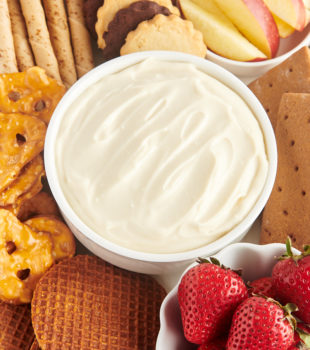 Bowl of cheesecake dip surrounded by assorted dippers