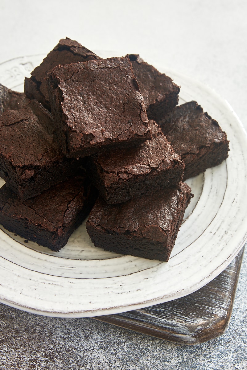 several cocoa powder brownies on a white plate