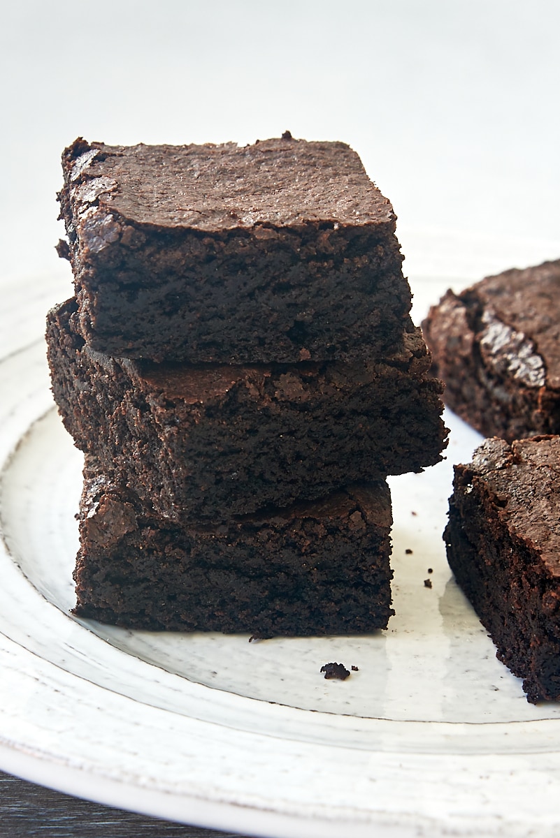 three cocoa powder brownies stacked on a plate