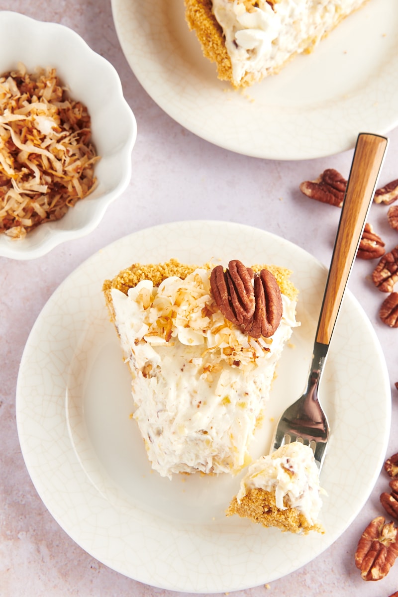 Overhead view of Slice of millionaire pie on plate with tip of pie on fork