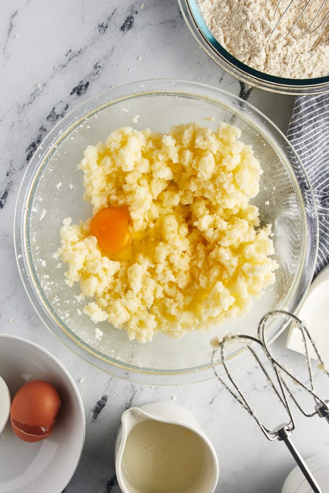 overhead view of egg and vanilla added to creamed butter and sugar in a glass mixing bowl