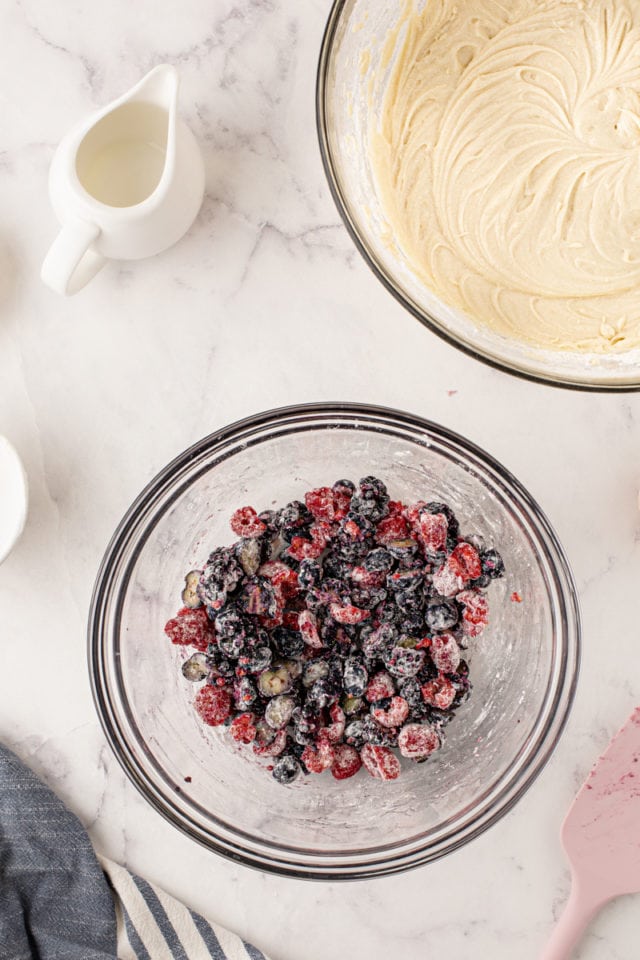 overhead view of berries tossed with flour in a glass mixing bowl