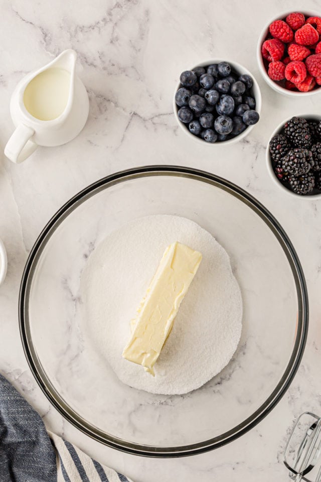 overhead view of butter and sugar in a glass mixing bowl