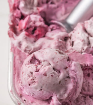 a container of blackberry ice cream with a scoop of the ice cream on top