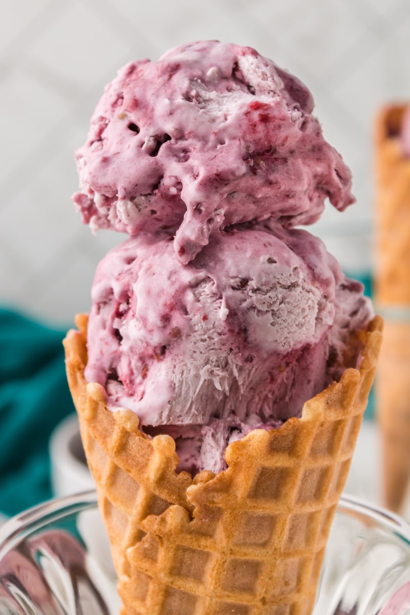 two scoops of blackberry ice cream in a waffle cone