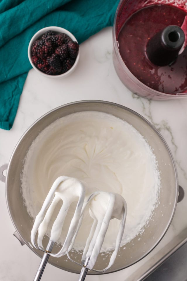 overhead view of partially whipped cream in a metal mixing bowl