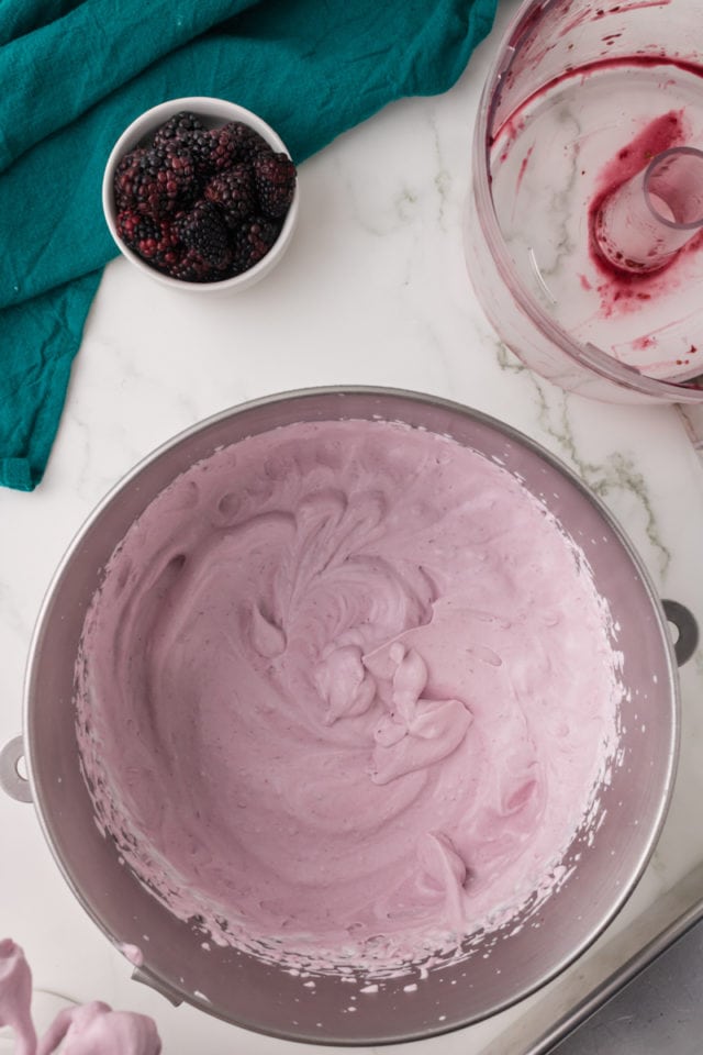 overhead view of mixed blackberry ice cream in a metal mixing bowl