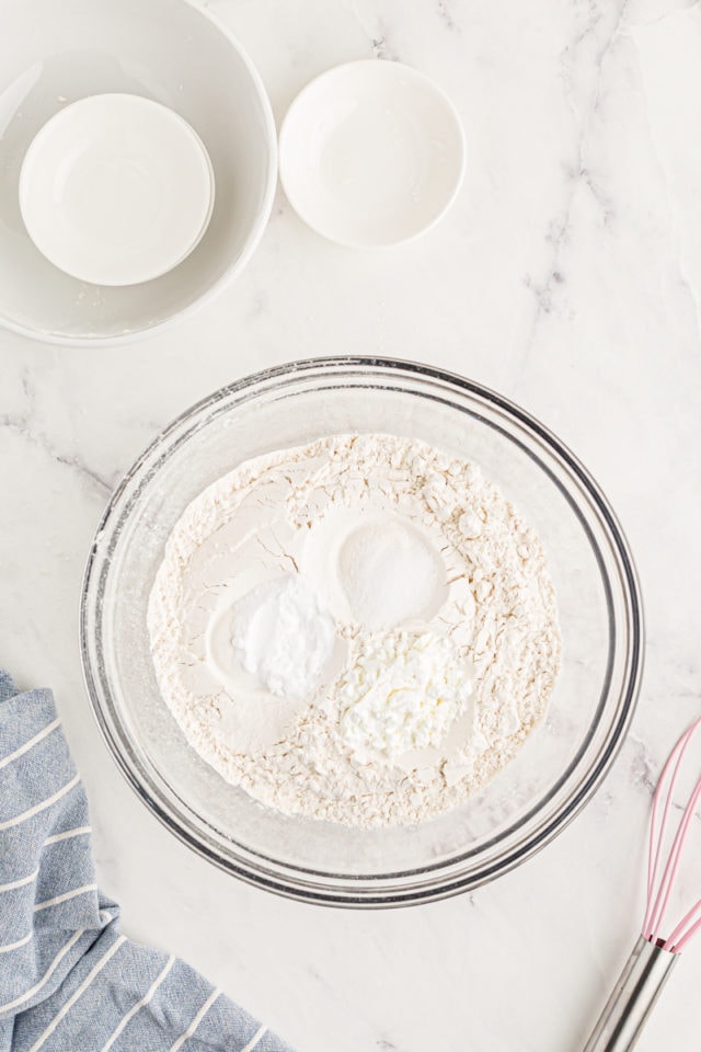 overhead view of flour, cornstarch, baking soda, and salt in a glass mixing bowl