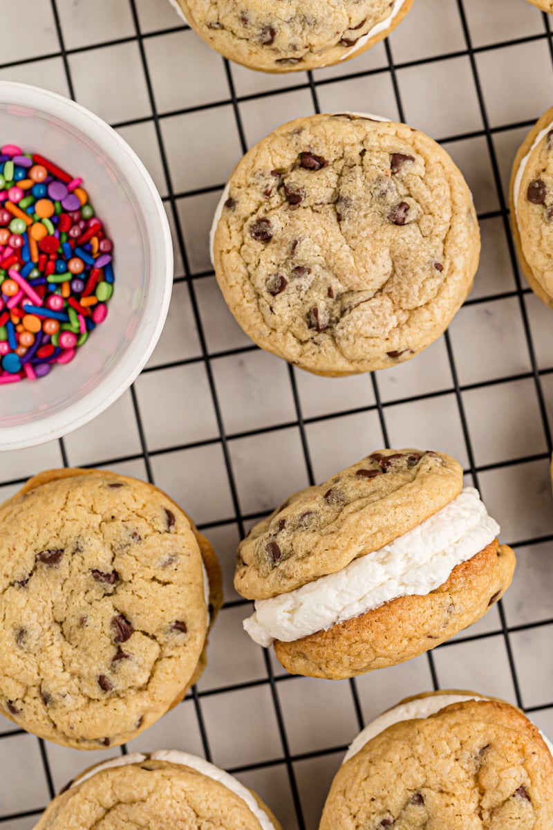 close up of Chocolate Chip Cookie Sandwiches on a wire rack with a bowl of colorful sprinkles