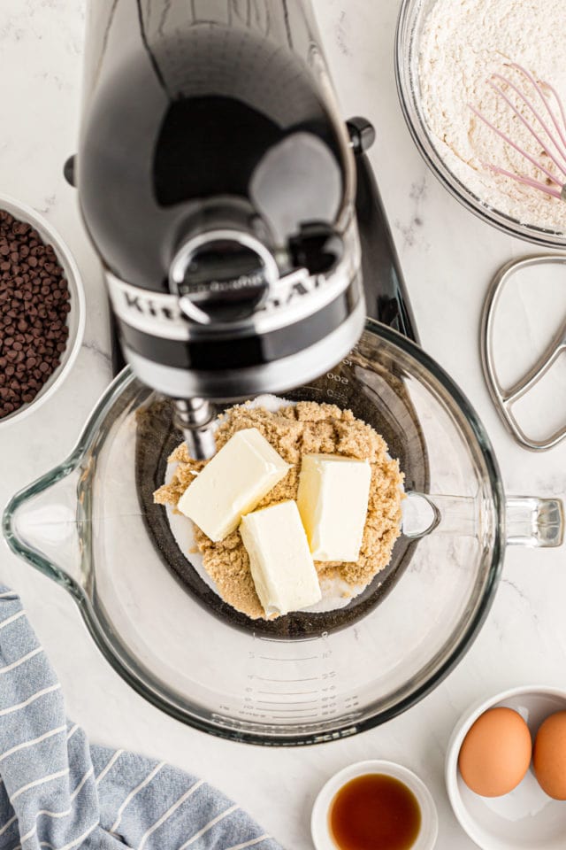 overhead view of butter, brown sugar, and sugar in the bowl of a stand mixer