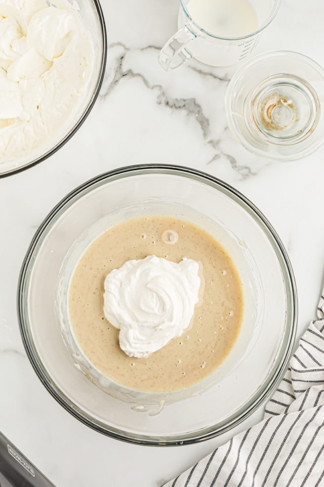 Overhead view of whipped cream added to condensed milk mixture