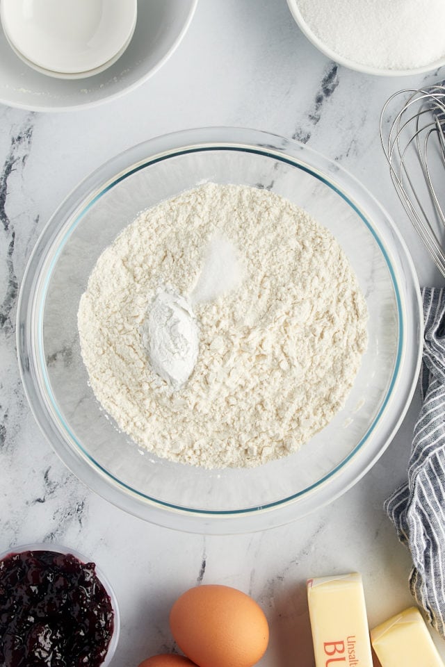 overhead view of flour, baking powder, and salt in a glass mixing bowl