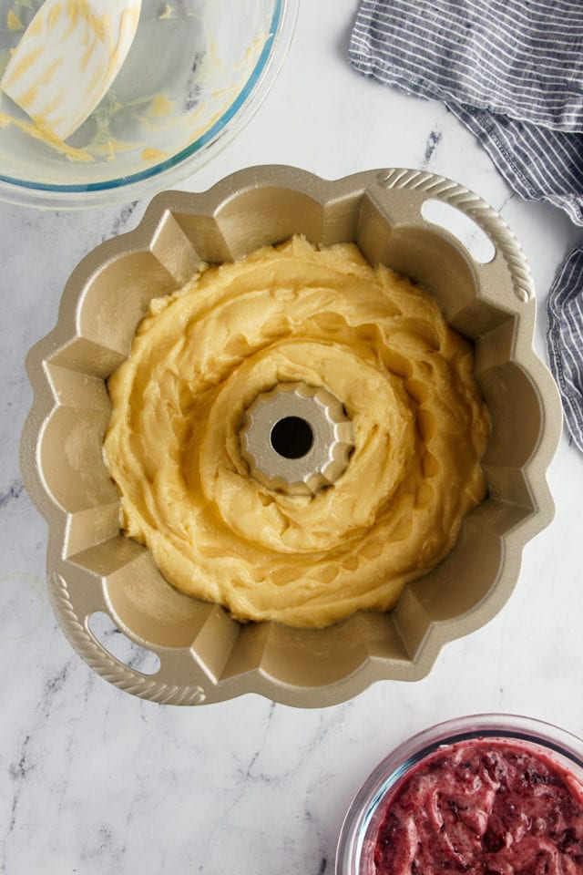 overhead view of black cherry sour cream coffee cake batter in a Bundt pan with a trough made in the center