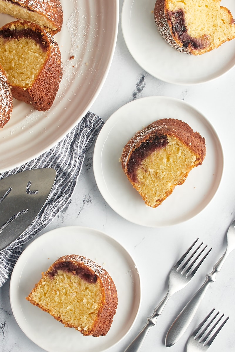 overhead view of slices of black cherry sour cream coffee cake on white plates