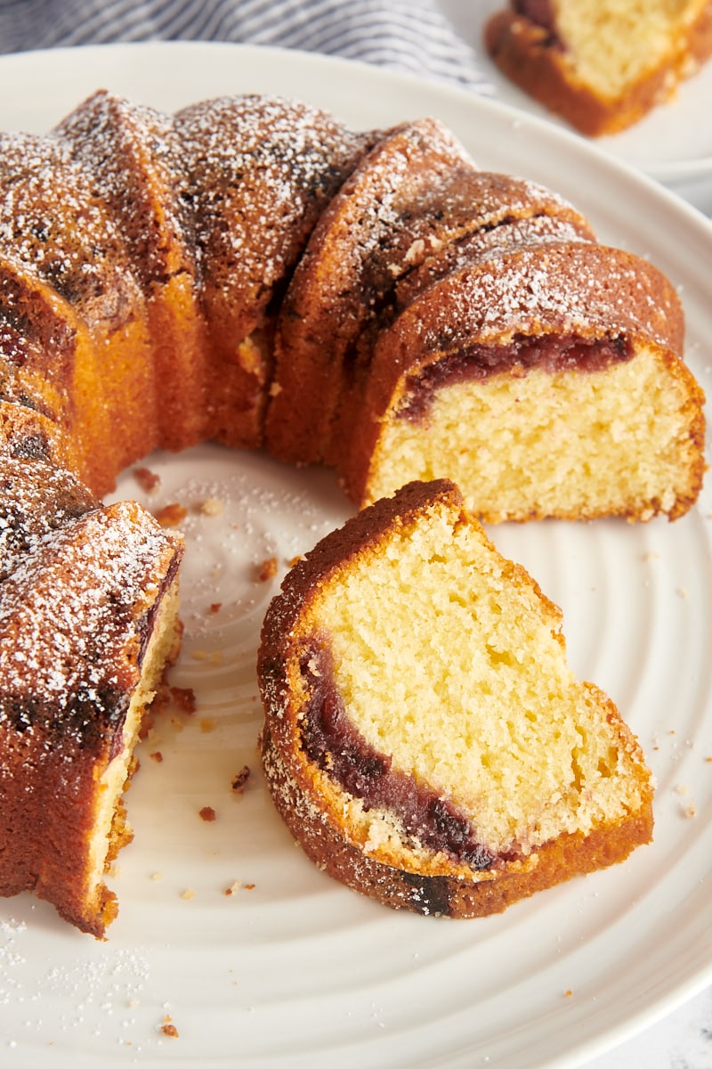 partially sliced black cherry sour cream coffee cake on a cake stand