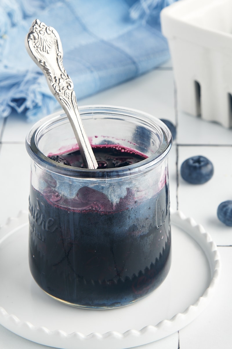 blueberry compote in a glass jar with a spoon in the jar