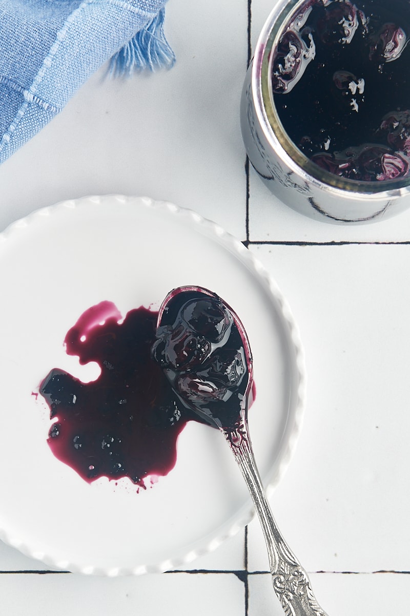blueberry compote and a spoon on a white plate