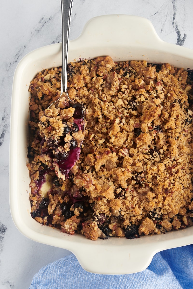 Baking dish of blueberry crisp with spoon