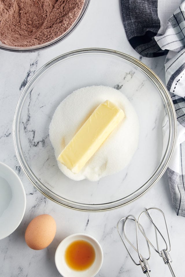 overhead view of sugar and butter in a glass mixing bowl