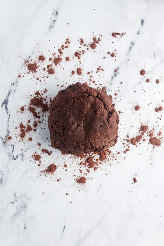 overhead view of chocolate wafer cookie dough on a marble surface dusted with cocoa powder