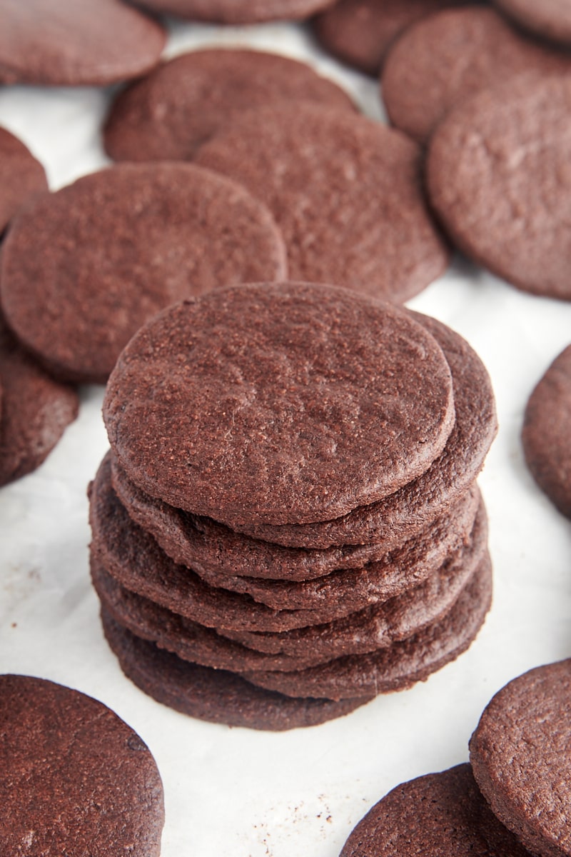 stack of nine chocolate wafer cookies surrounded by more cookies