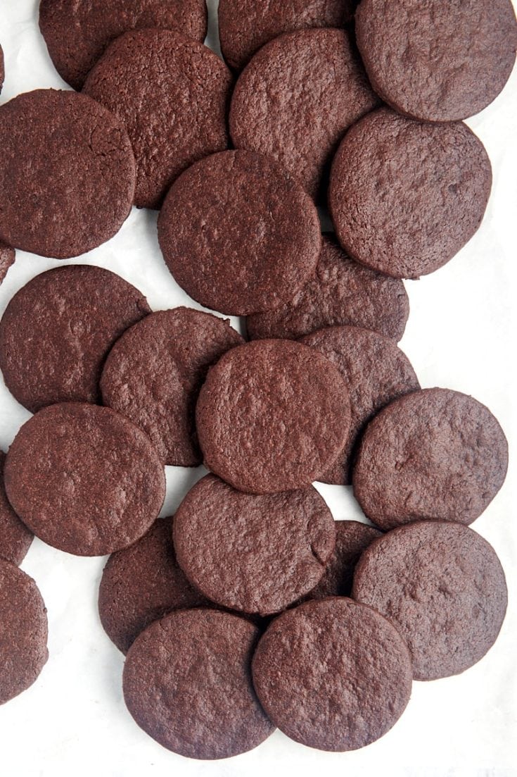 overhead view of chocolate wafer cookies scattered over a white surface
