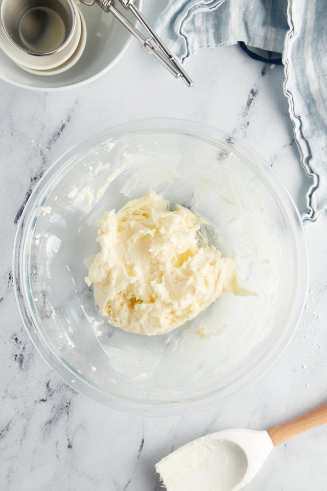 overhead view of vanilla frosting in a glass mixing bowl
