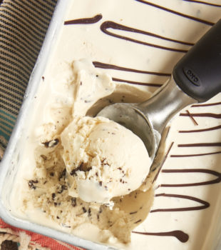 Overhead view of ice cream scooper scooping stracciatella ice cream from pan