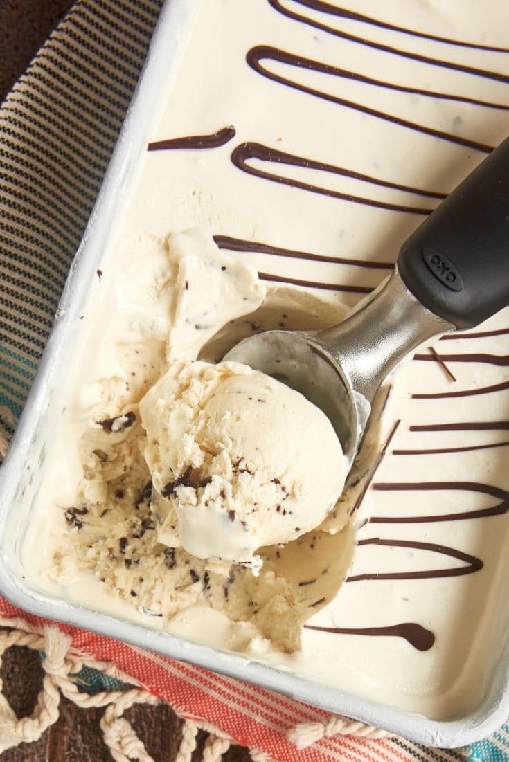 Overhead view of ice cream scooper scooping stracciatella ice cream from pan