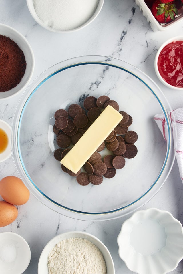 Overhead view of butter and chocolate discs in mixing bowl