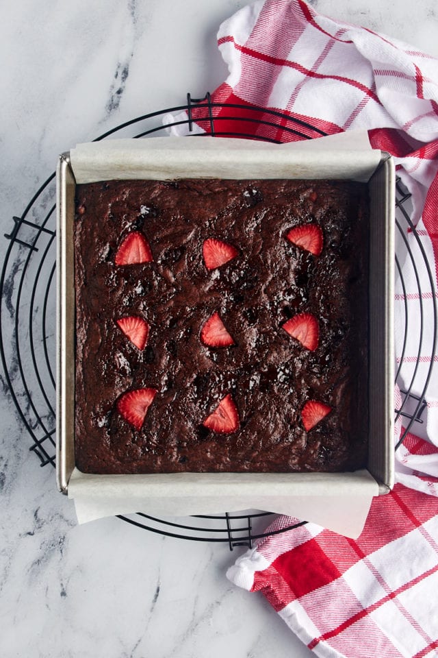 Overhead view of strawberry brownies in pan on wire cooling rack